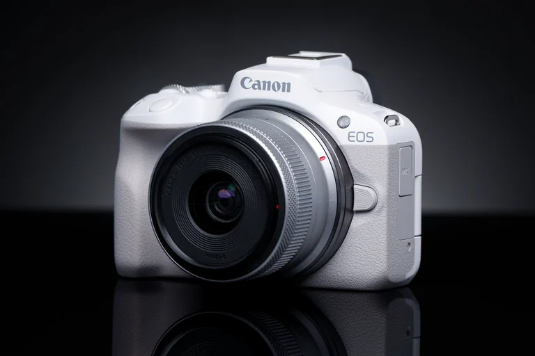 Canon EOS R50 mirrorless camera on a dark product-photography background.
