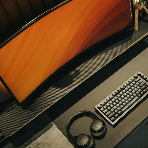 Ultrawide monitor, keyboard, mouse, and headphones on a premium desk setup.