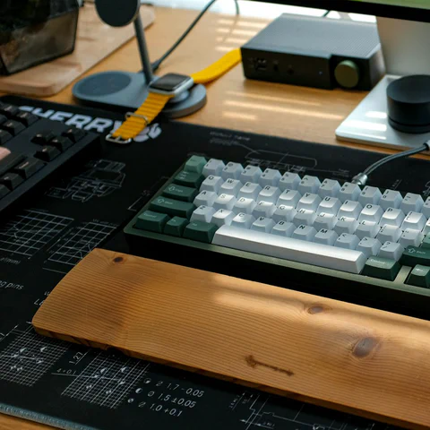 Escritorio premium con teclado mecánico, monitor, ratón y reposamuñecas de madera.