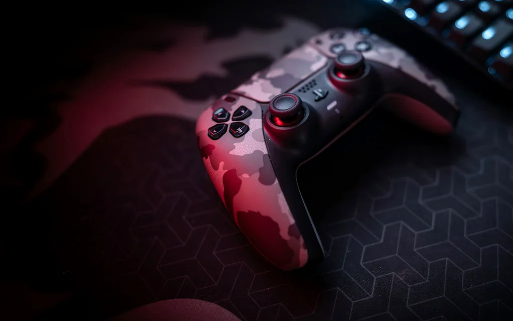 Game controller and keyboard on a dark gaming desk.