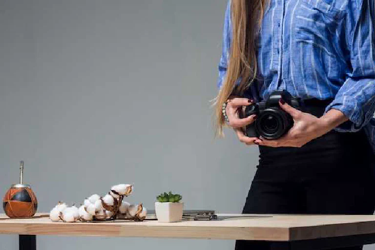 A person holding their first mirrorless camera, looking thoughtfully at the settings before taking a photo.