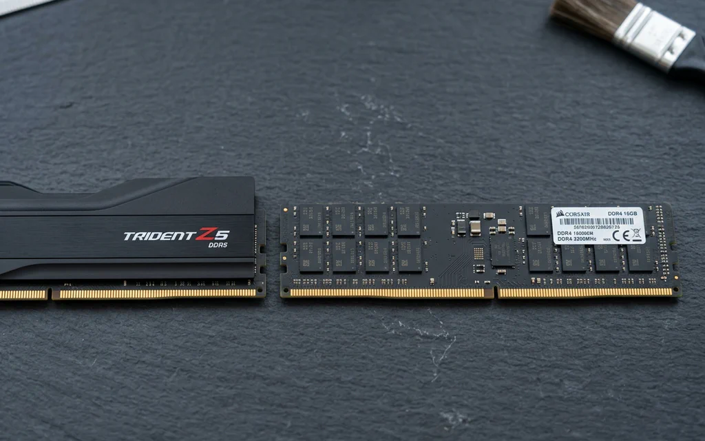 DDR5 and DDR4 desktop memory modules side by side on a slate workbench.