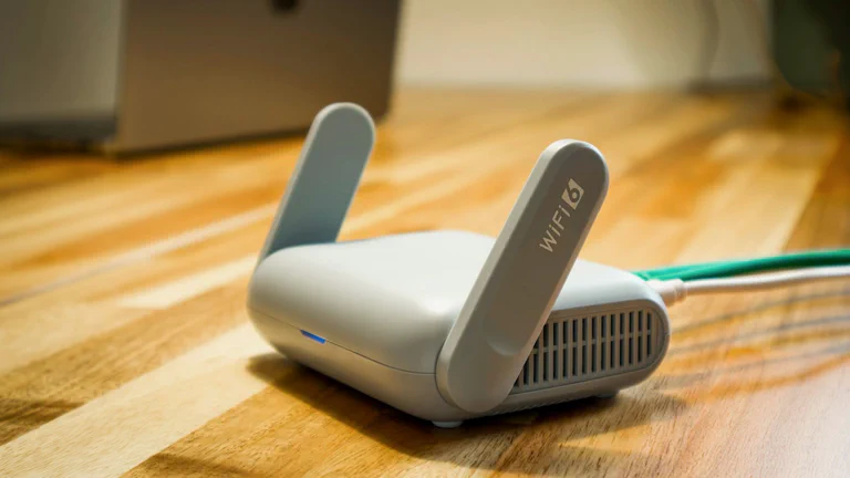 Close em um roteador Wi‑Fi doméstico sobre uma mesa com cabo Ethernet conectado.