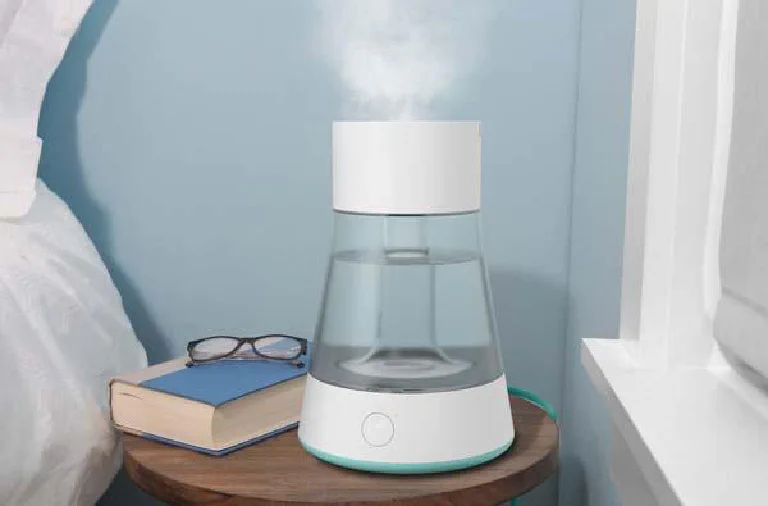 A modern ultrasonic humidifier emitting a cool mist in a cozy, well-lit living room.