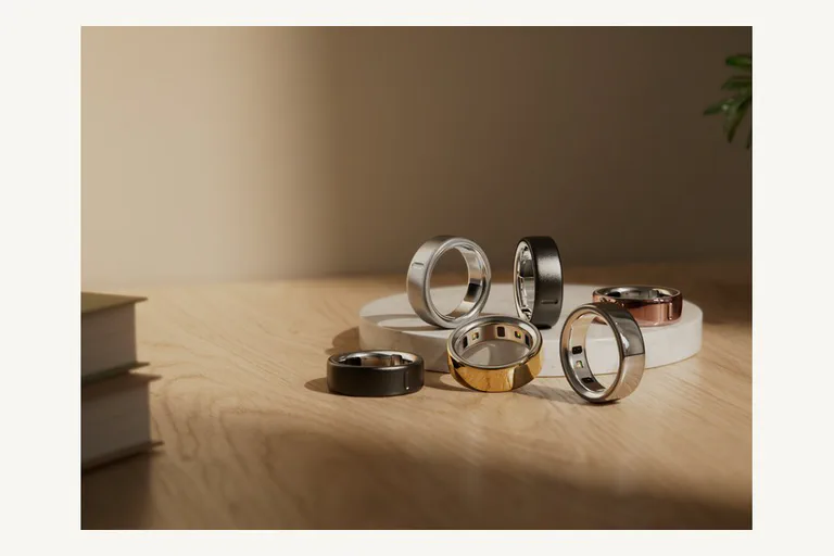 Offizielles Oura-Ring-4-Produktbild mit mehreren Ringfarben auf einem Tisch.